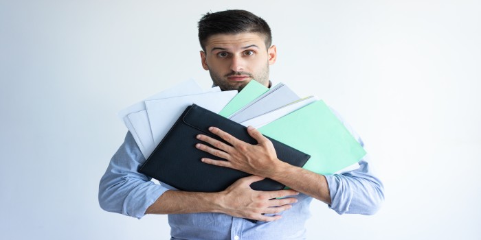 puzzled-office-worker-holding-pile-documents (1) puzzled-office-worker-holding-pile-documents (1)